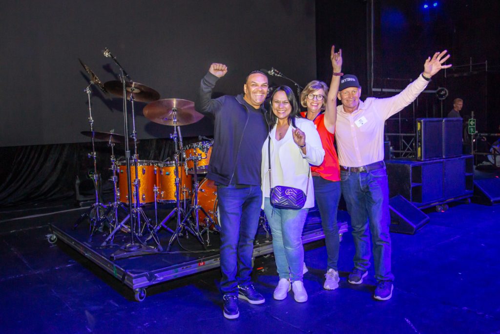 Sales Force image. People on a stage with drums in the background